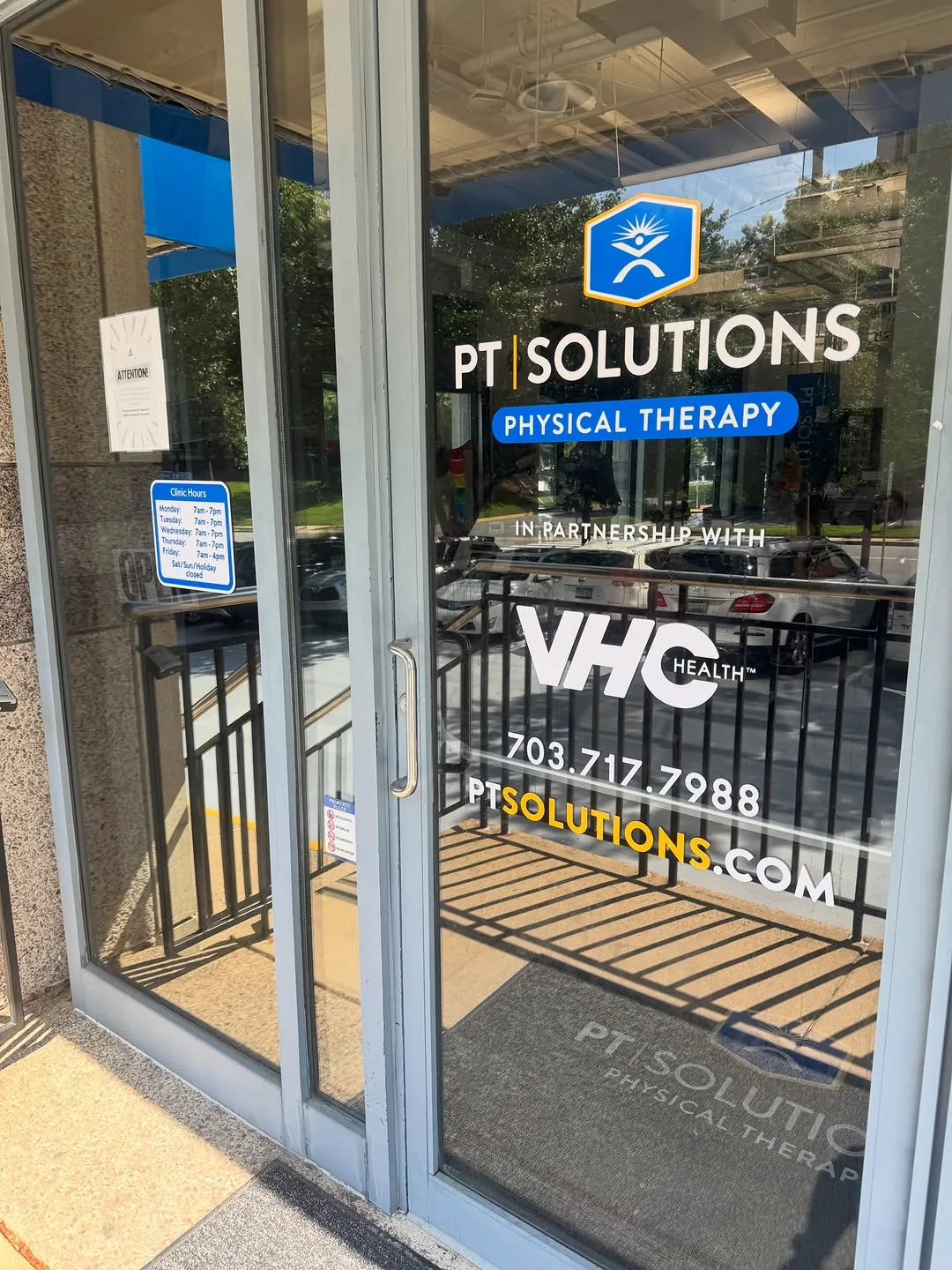 Glass entry doors with PT Solutions Physical Therapy window vinyl and phone number