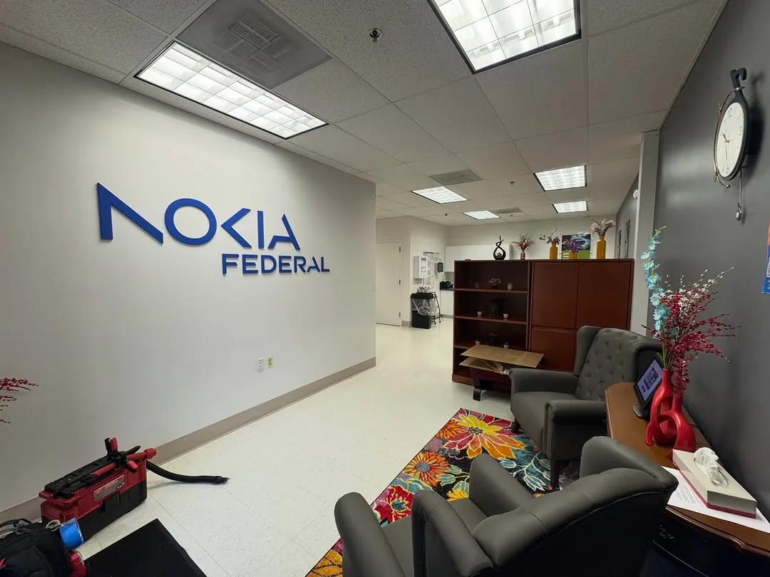 Nokia Federal wall lettering seen from across a reception area with tool cases on the floor