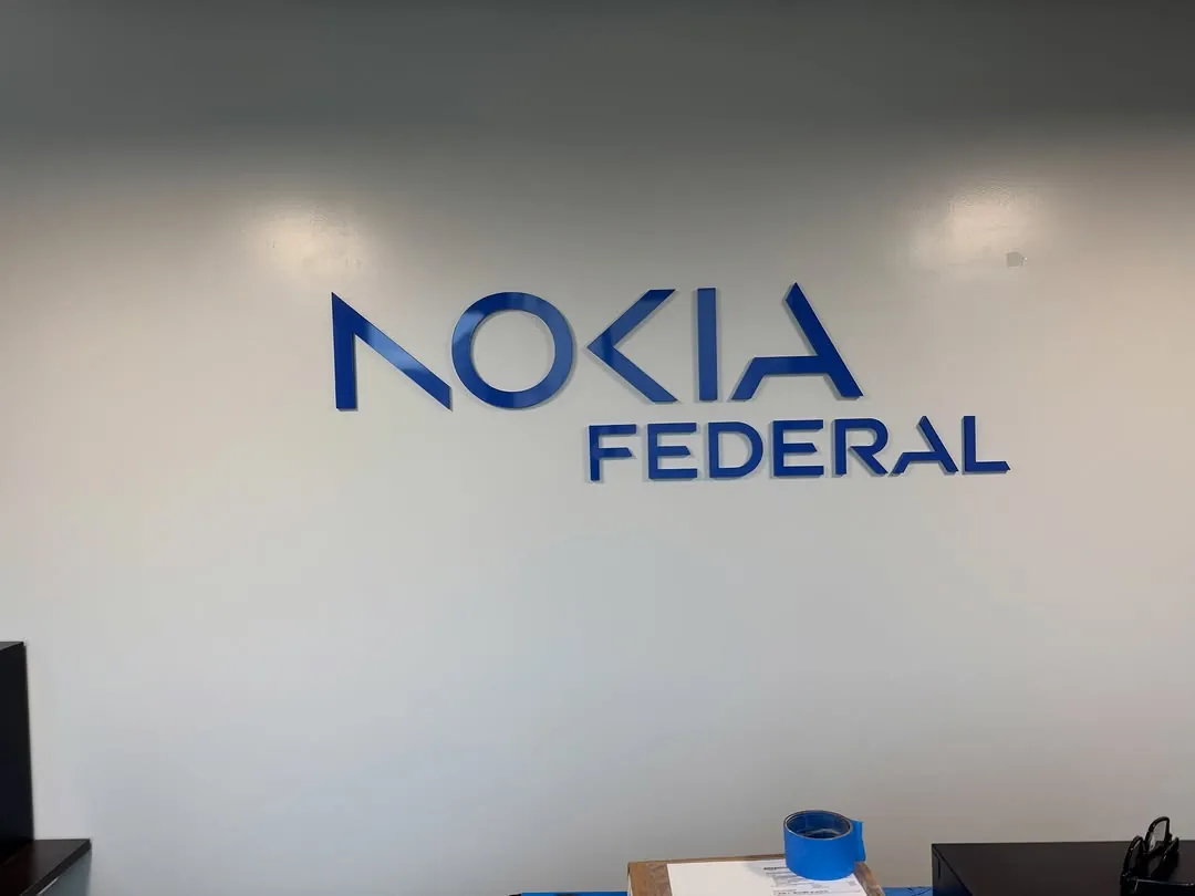 Brushed dimensional letters reading Nokia Federal mounted on a white office wall